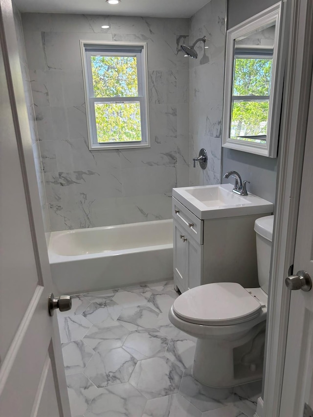 full bath with plenty of natural light, marble finish floor, washtub / shower combination, and toilet