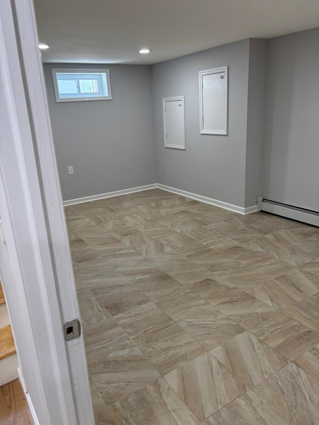below grade area featuring recessed lighting, baseboards, and a baseboard radiator