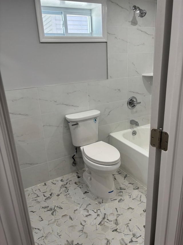 bathroom featuring tile walls, bathtub / shower combination, and toilet