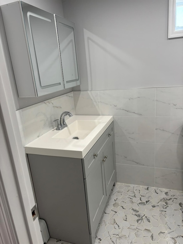 bathroom featuring vanity, a wainscoted wall, and tile walls