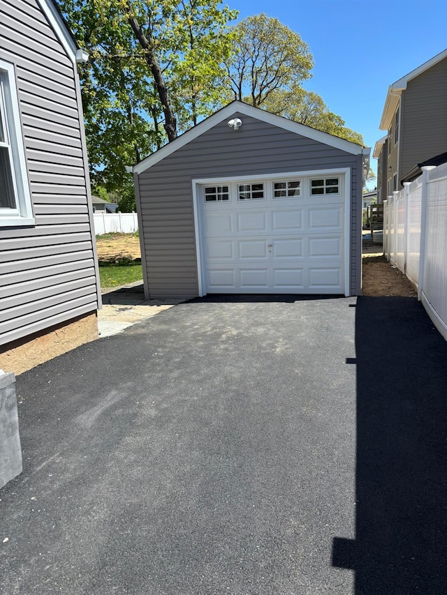 detached garage with fence and driveway