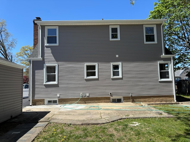 back of house featuring a patio and a chimney