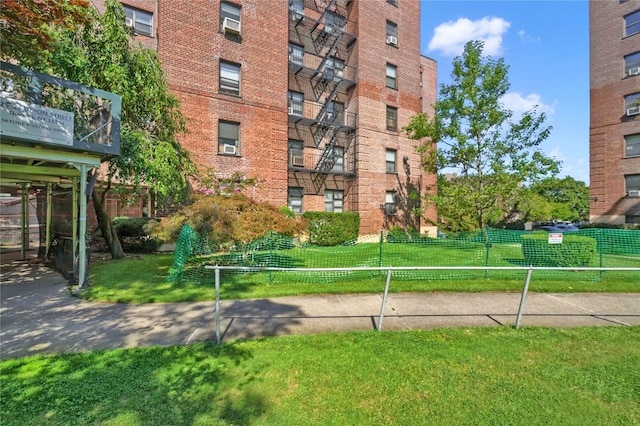 view of home's community with fence and a lawn