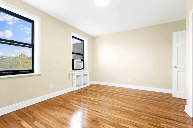 25-40 Union St Unit 6B, Flushing, NY 11354 - unfurnished room featuring cooling unit, baseboards, and light wood-style floors