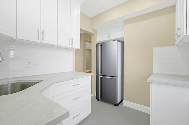 25-40 Union St Unit 6B, Flushing, NY 11354 - kitchen with light stone countertops, a sink, freestanding refrigerator, white cabinetry, and baseboards