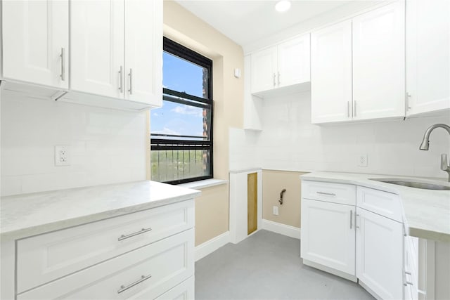 25-40 Union St Unit 6B, Flushing, NY 11354 - kitchen featuring baseboards, white cabinets, light stone counters, a sink, and backsplash