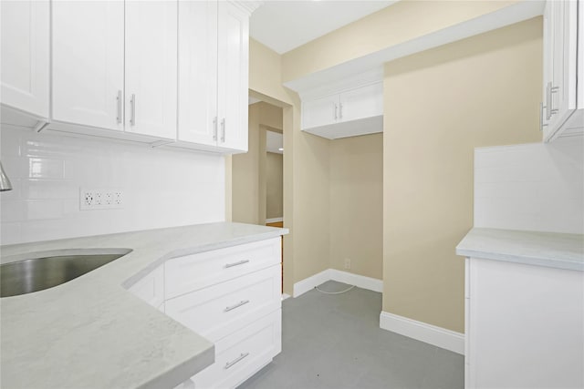 25-40 Union St Unit 6B, Flushing, NY 11354 - kitchen featuring baseboards, white cabinetry, light stone counters, a sink, and backsplash