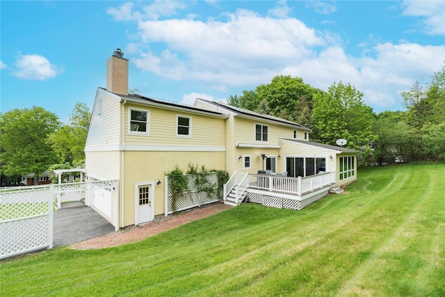 16 Charlotte Dr, Lagrangeville, NY 12540 - back of house with a chimney, a deck, a lawn, driveway, and an attached garage