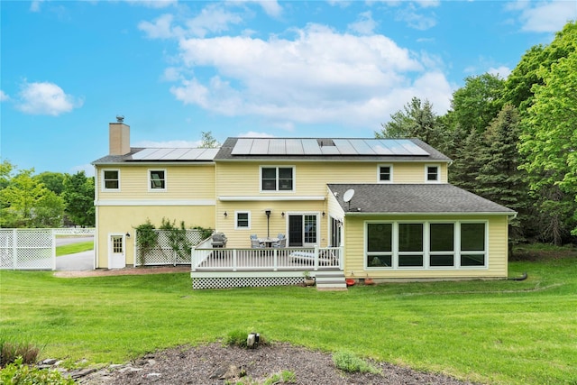 16 Charlotte Dr, Lagrangeville, NY 12540 - back of house with a chimney, a deck, solar panels, and a standing seam roof