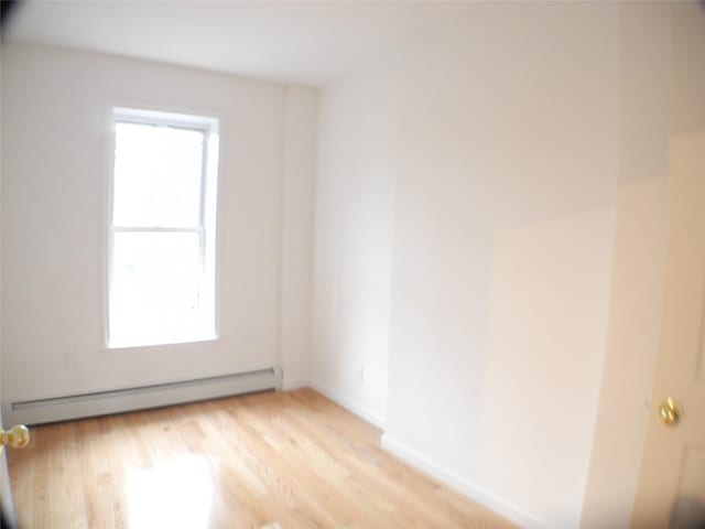 237 Madison St, Brooklyn, NY 11216 - unfurnished room featuring a baseboard heating unit, light wood finished floors, and baseboards