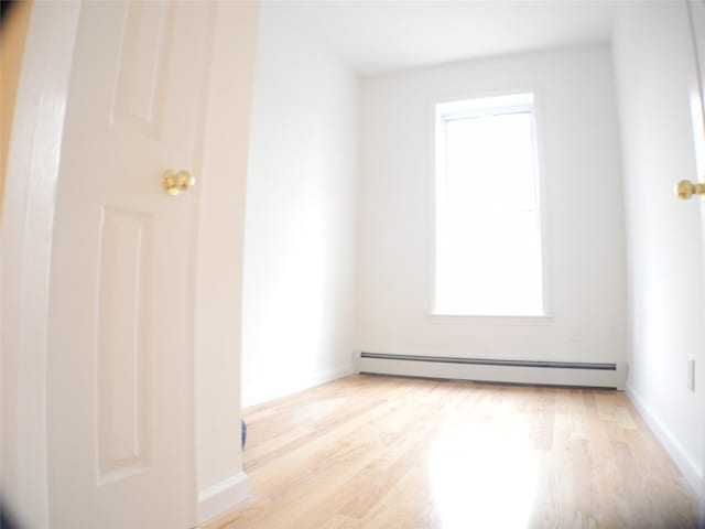 237 Madison St, Brooklyn, NY 11216 - spare room featuring a baseboard radiator, light wood-style floors, and baseboards