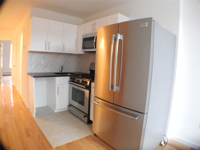 237 Madison St, Brooklyn, NY 11216 - kitchen with stainless steel appliances, white cabinets, tasteful backsplash, a sink, and dark countertops