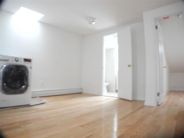 237 Madison St, Brooklyn, NY 11216 - laundry room with washer / dryer, a baseboard heating unit, and wood finished floors