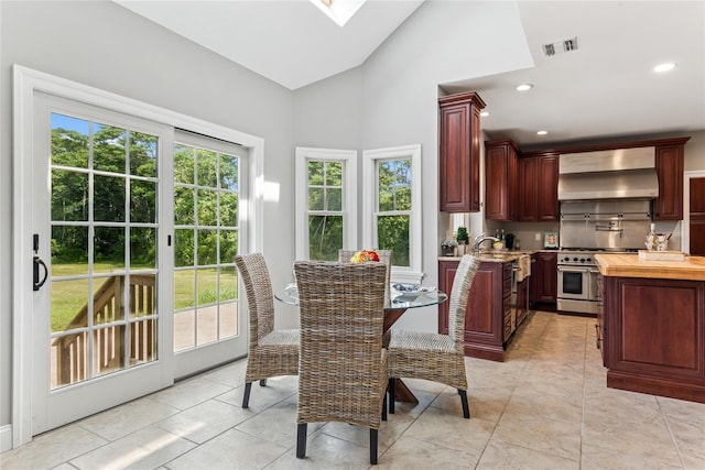 1465 Ackerly Pond Ln, Southold, NY 11971 - dining area with high vaulted ceiling, light tile patterned floors, recessed lighting, and a skylight
