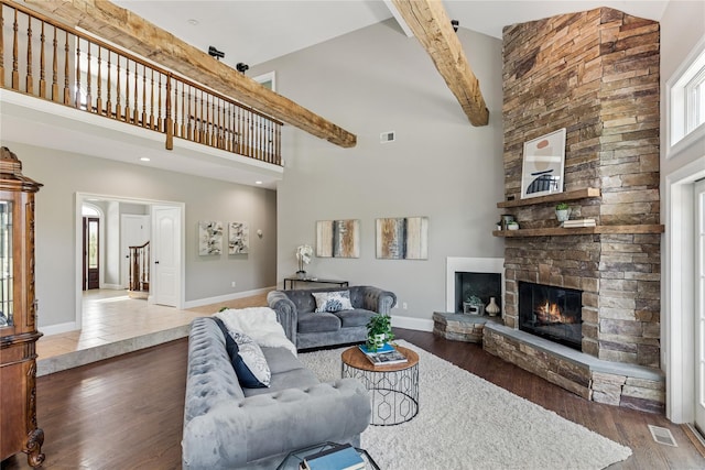 1465 Ackerly Pond Ln, Southold, NY 11971 - living area featuring high vaulted ceiling, a stone fireplace, wood finished floors, plenty of natural light, and beam ceiling