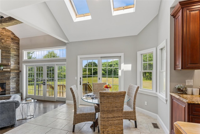 1465 Ackerly Pond Ln, Southold, NY 11971 - dining space featuring high vaulted ceiling, plenty of natural light, a stone fireplace, and french doors