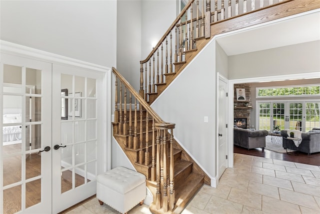 1465 Ackerly Pond Ln, Southold, NY 11971 - stairs with french doors, a towering ceiling, and a glass covered fireplace