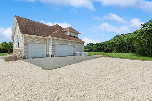 1465 Ackerly Pond Ln, Southold, NY 11971 - view of side of home with gravel driveway, a garage, and roof with shingles