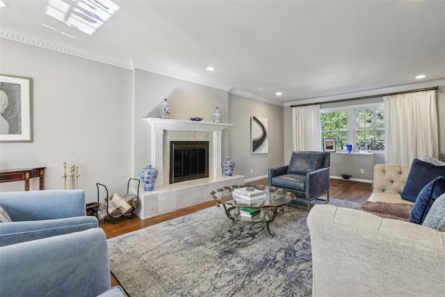 living area featuring wood finished floors, ornamental molding, recessed lighting, a high end fireplace, and baseboards