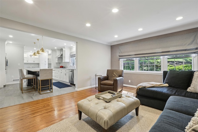 living room featuring crown molding, light wood-type flooring, recessed lighting, and baseboards