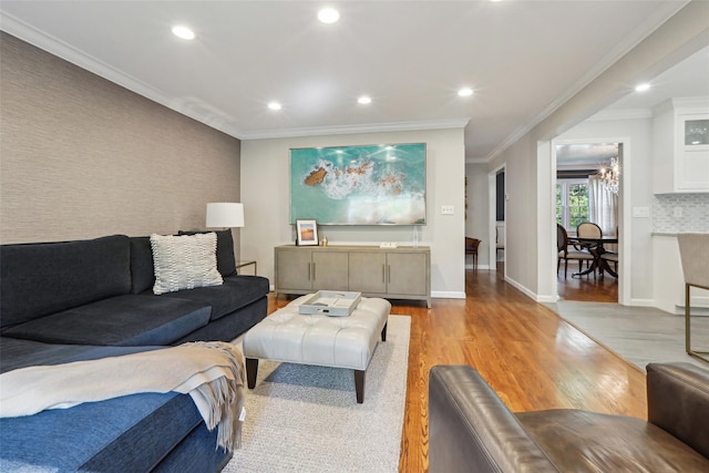 living area with light wood finished floors, recessed lighting, a chandelier, baseboards, and ornamental molding