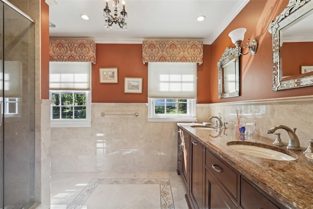 bathroom featuring tile walls, a shower stall, wainscoting, crown molding, and double vanity