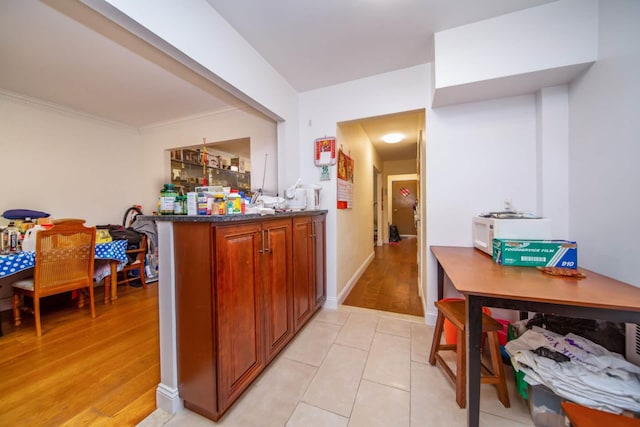 interior space with ornamental molding and light tile patterned floors