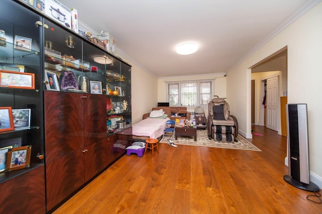 sitting room featuring crown molding, baseboards, and wood finished floors