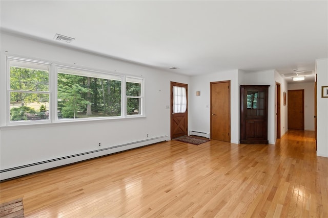 720 Midwood Rd, Cutchogue, NY 11935 - unfurnished living room with a baseboard heating unit and light wood-type flooring