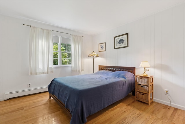 720 Midwood Rd, Cutchogue, NY 11935 - bedroom featuring a baseboard heating unit and wood finished floors