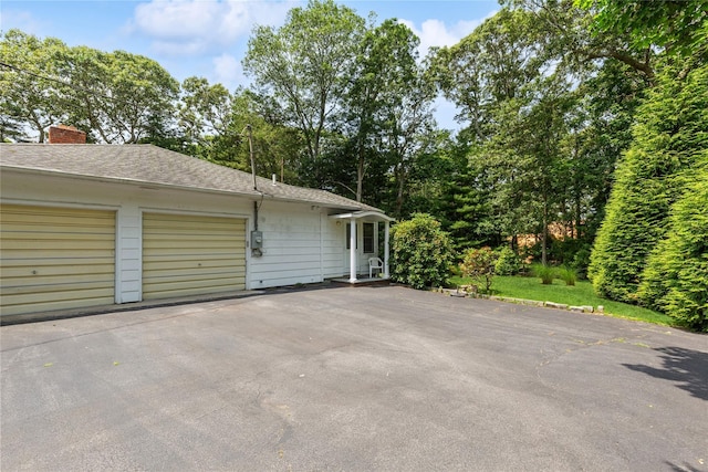 720 Midwood Rd, Cutchogue, NY 11935 - view of side of home featuring driveway, roof with shingles, and a chimney
