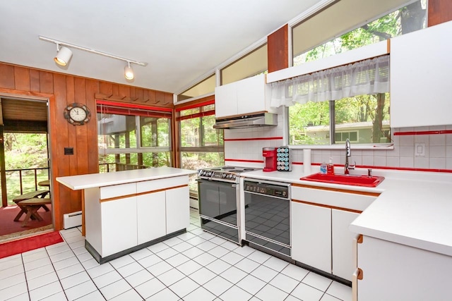 kitchen featuring a sink, black dishwasher, range with electric cooktop, and light countertops