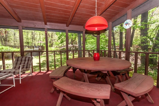 sunroom featuring beam ceiling