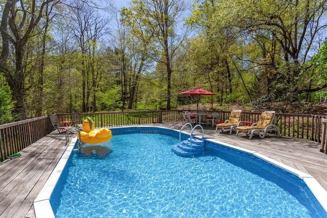 view of swimming pool featuring a fenced in pool and a deck