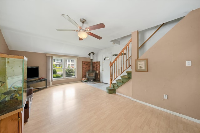 96 Pardee Ave, Islip, NY 11751 - unfurnished living room with a wood stove, stairway, light wood-style flooring, ceiling fan, and baseboards