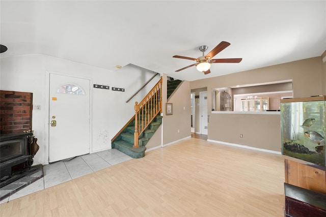 96 Pardee Ave, Islip, NY 11751 - unfurnished living room featuring a wood stove, stairway, ceiling fan, and plenty of natural light