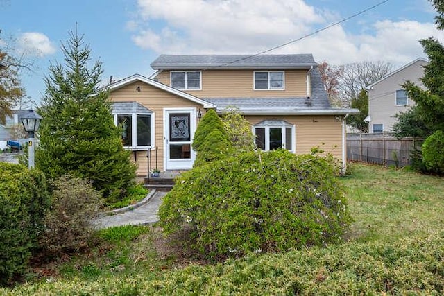 view of front of house with fence and a front lawn