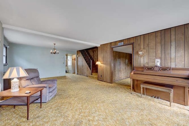 living area featuring stairs, a notable chandelier, wooden walls, and light carpet