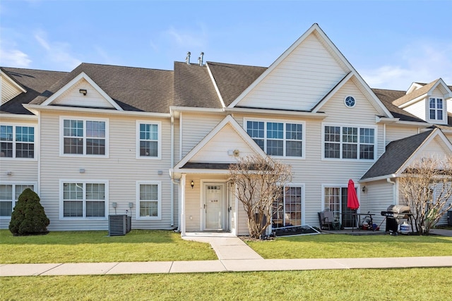 multi unit property featuring roof with shingles and a front lawn