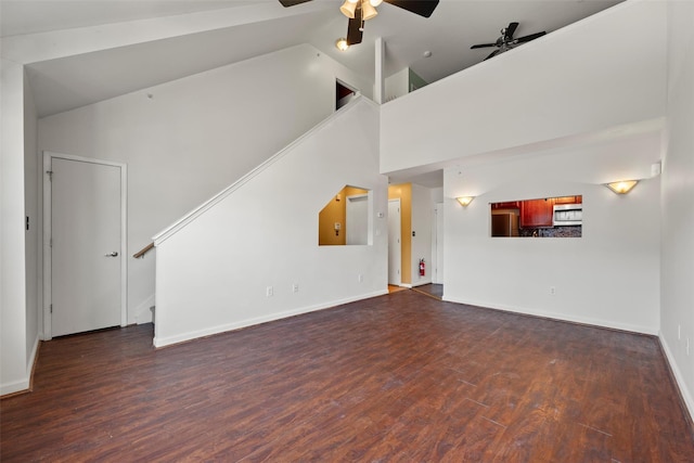 unfurnished living room with ceiling fan, high vaulted ceiling, stairs, baseboards, and dark wood-type flooring