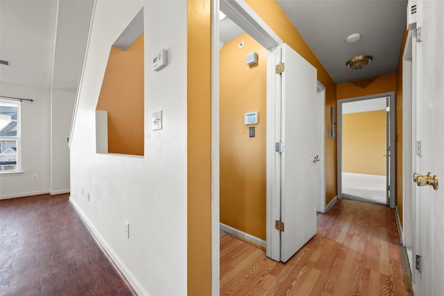 hall featuring baseboards and wood finished floors