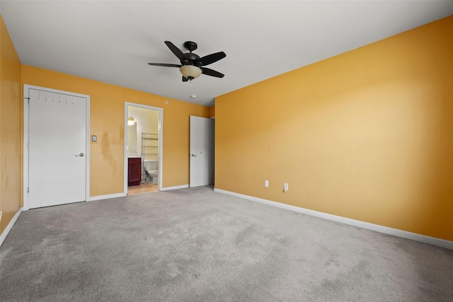 unfurnished bedroom with baseboards, a ceiling fan, carpet flooring, and connected bathroom
