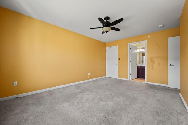 unfurnished bedroom featuring baseboards, ceiling fan, carpet, and ensuite bath
