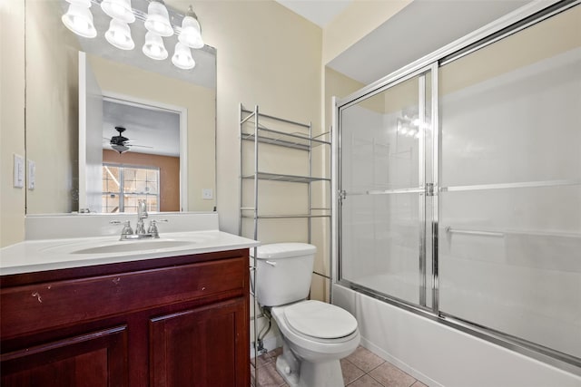 full bathroom featuring ceiling fan, tile patterned floors, vanity, toilet, and shower / bath combination with glass door