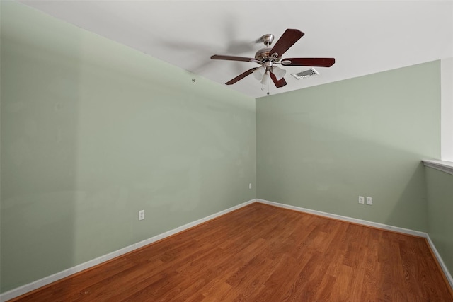 unfurnished room with visible vents, baseboards, ceiling fan, and wood finished floors