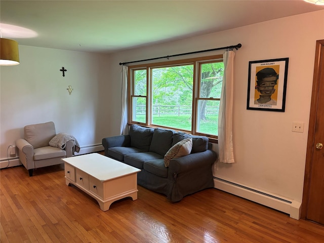living area with a baseboard heating unit and light wood-style floors