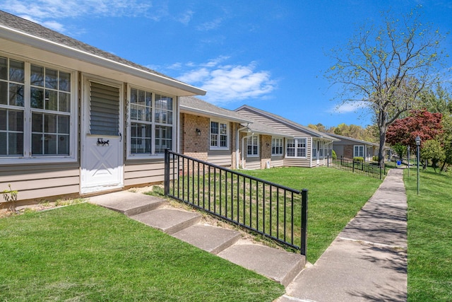 view of exterior entry featuring brick siding and a yard