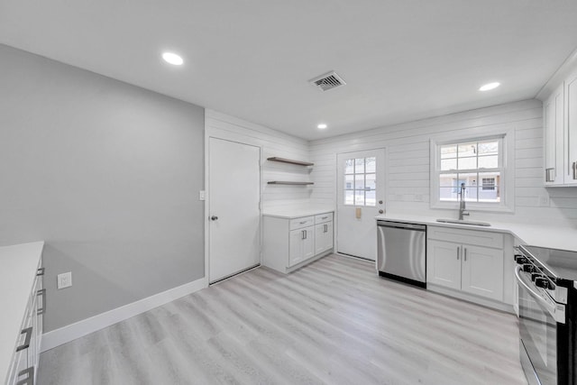 kitchen with visible vents, light wood-type flooring, white cabinetry, a sink, and stainless steel appliances