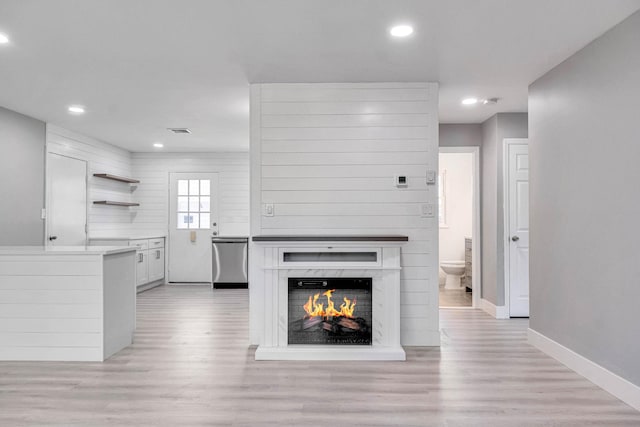 unfurnished living room featuring recessed lighting, baseboards, and light wood-type flooring