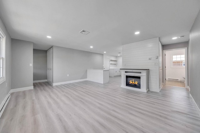 unfurnished living room featuring baseboards, recessed lighting, and light wood-style floors